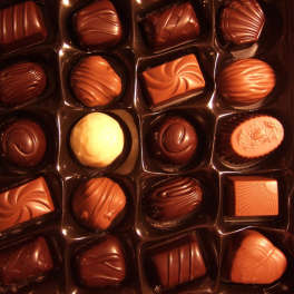 Assorted chocolates in a box with molded tops