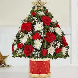 Christmas tree-shaped floral arrangement in a red drum container