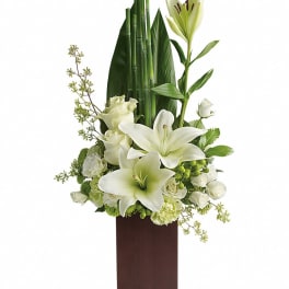 White lilies and roses arranged in a tall brown vase