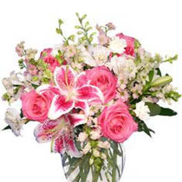 Pink roses and lilies arranged in a clear glass vase