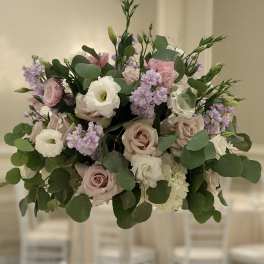 Tall floral centerpiece with blush roses, white blooms, and lavender accents