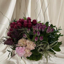 Bouquet of purple roses, tulips, and hydrangeas with decorative grasses