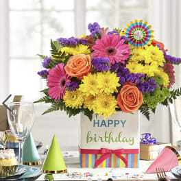 Birthday flower arrangement in a decorated gift box with bright mixed blooms
