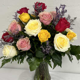 Mixed roses in pink, red, yellow, and white in a glass vase