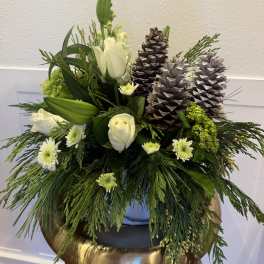 White roses and lilies with pinecones in a low arrangement