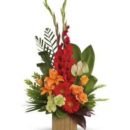 Tall tropical-style arrangement with red, orange, and green flowers in a rectangular wooden container
