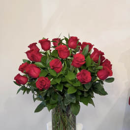 Red roses arranged in a clear glass vase