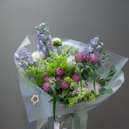 Lavender and pink bouquet in a glass vase with ribbon