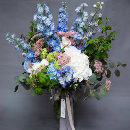 Large bouquet of blue and white flowers in a glass vase