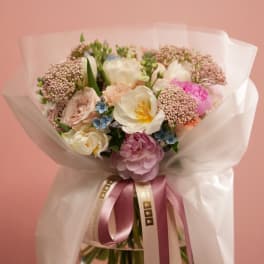 Pastel bouquet with white and pink flowers wrapped in white paper