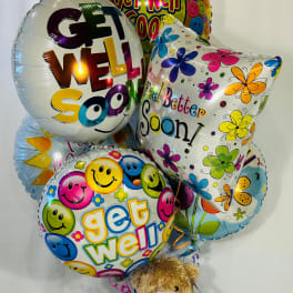 Cluster of get-well balloons with a teddy bear at the base