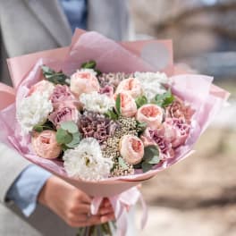 Pink and white bouquet of mixed flowers wrapped in pink paper