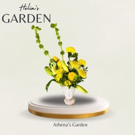 Yellow floral arrangement in a white face-shaped vase