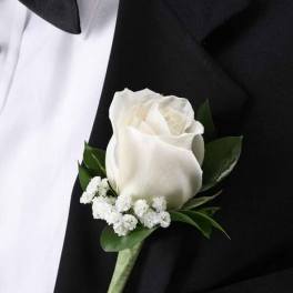 White rose boutonniere with small white filler flowers on a black suit lapel