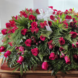 Large red rose casket spray with white ribbon