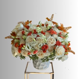 Large bouquet of white and coral roses in a textured white vase