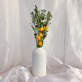 Tall bouquet of yellow and white roses in a white vase