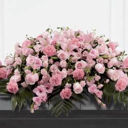 Large pink floral casket spray with lilies and roses
