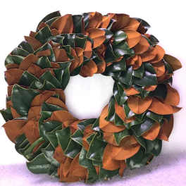Circular wreath made of glossy green and copper leaves