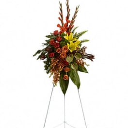 Standing floral spray with red and yellow flowers on an easel