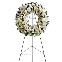 White floral funeral wreath on a standing easel