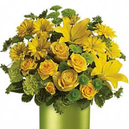 Yellow roses and lilies in a green cylindrical vase