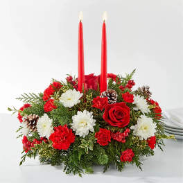 Holiday centerpiece with red candles, roses, carnations, and white daisies