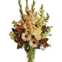 Peach and cream floral arrangement in a clear glass vase
