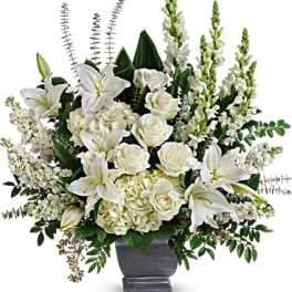 White lilies and roses arranged in a gray urn vase