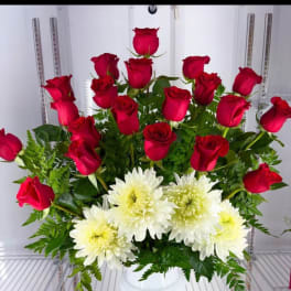 Red roses and white chrysanthemums arranged in a white vase