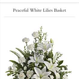 White lilies and carnations arranged in a wicker basket