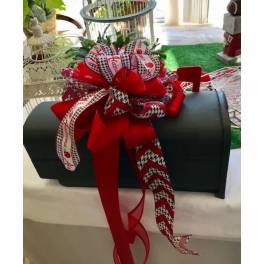 Black chest with a large red and patterned ribbon bow