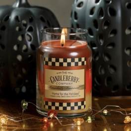Lit candle in a glass jar with a holiday label