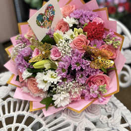 Pink and purple bouquet with roses, daisies, and a LOVE card
