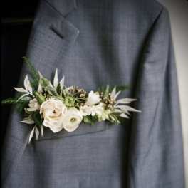 White floral boutonniere pinned to a gray suit jacket