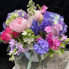 Pastel bouquet of peonies, hydrangeas, and hyacinths in a white vase