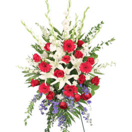 Standing floral spray with red roses, white lilies, and purple accents