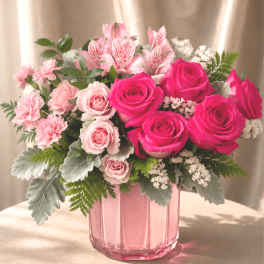 Pink roses and carnations in a pink glass vase