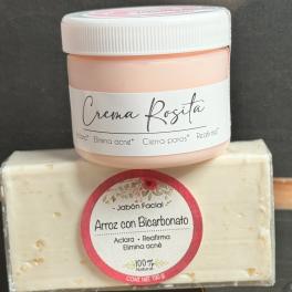 A pink cream jar sits on top of a wrapped facial soap bar.