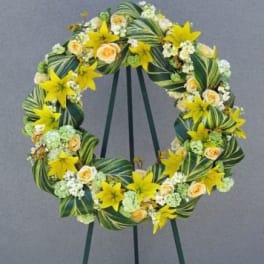Yellow and cream floral wreath on a stand