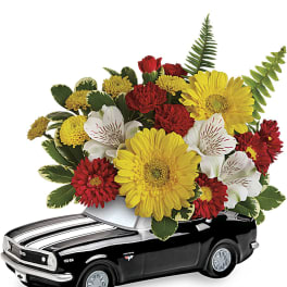 Flower arrangement in a black toy car container