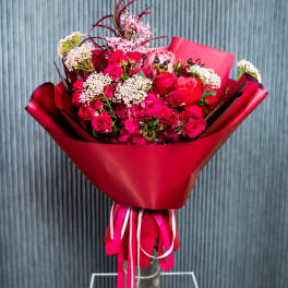 Bouquet of red and pink roses wrapped in red paper