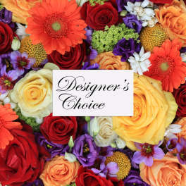 Mixed bouquet of roses, gerbera daisies, and purple blooms with a designer's choice card