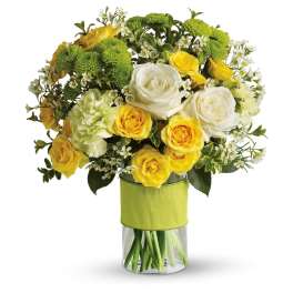 Yellow and white roses with green mums in a clear vase