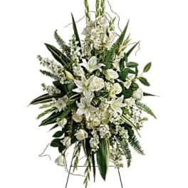 White floral standing spray on an easel with greenery