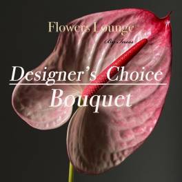 Pink anthurium bloom with a red spadix on a dark background