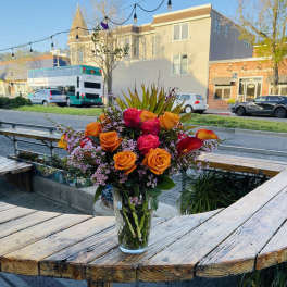 Bouquet of orange and pink roses in a clear glass vase