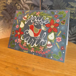 Holiday card with a bird and the words "peace on earth"