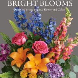 Bright mixed bouquet with roses, lilies, and tall blue and pink blooms