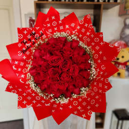 Red rose bouquet wrapped in patterned red paper